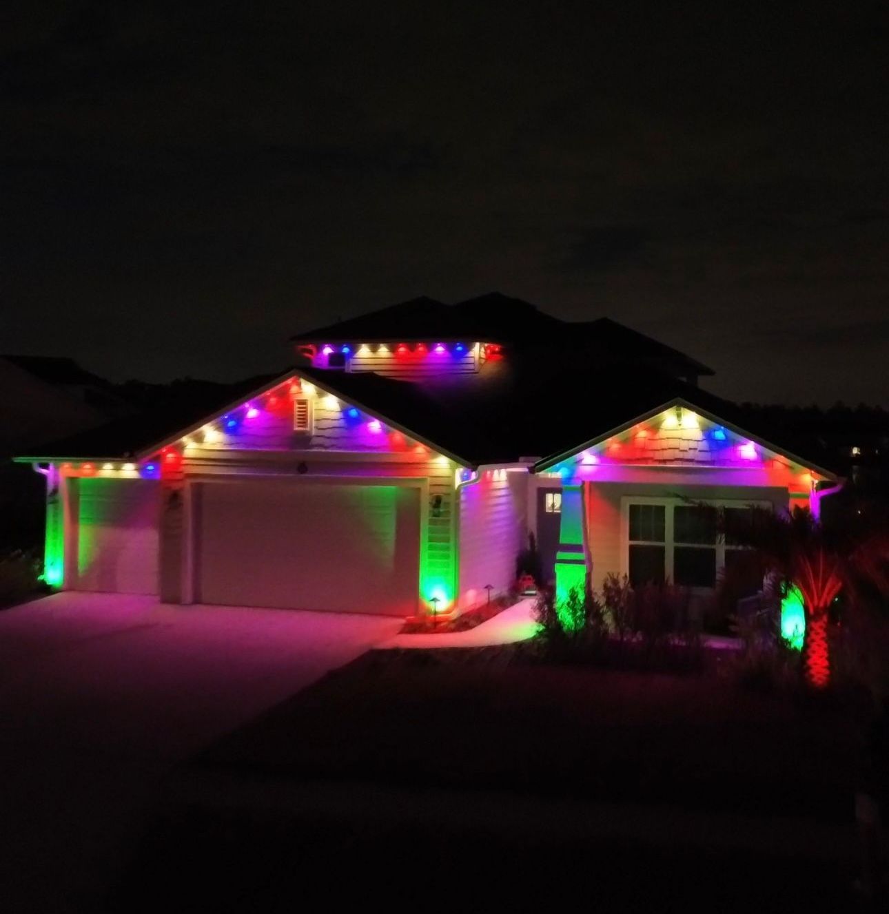 Home with full-color permanent roofline and landscape lighting