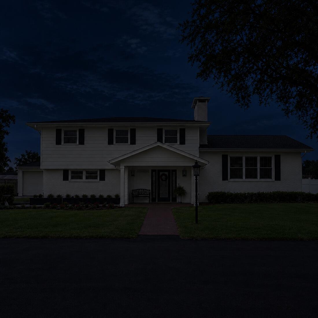 A home at night with no permanent lighting, dark apart from the porch